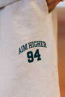 Aim Higher Club Unisex College Badge Sweatpants/ Oat